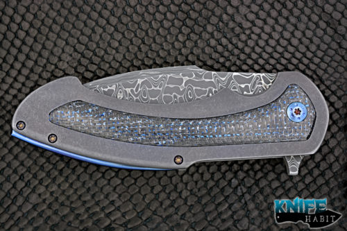 custom rick barrett full size fallout knife, stainless damascus blade steel, tumbled stonewashed titanium frame, blue mylar light strike carbon fiber inlays, timascus clip, blue anodized hardware