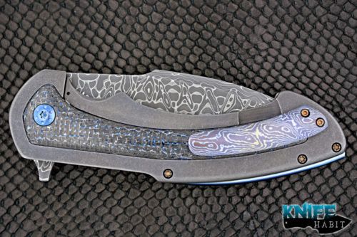 custom rick barrett full size fallout knife, stainless damascus blade steel, tumbled stonewashed titanium frame, blue mylar light strike carbon fiber inlays, timascus clip, blue anodized hardware