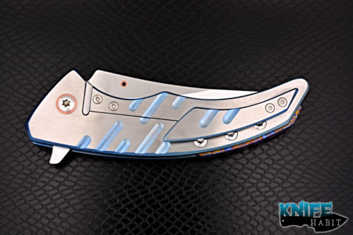 custom sergey rogovets model 19 knife, blue anodized milled titanium frame, cts-xhp blade steel, satin finish, mokuti backspacer, copper pivot collar and inlay